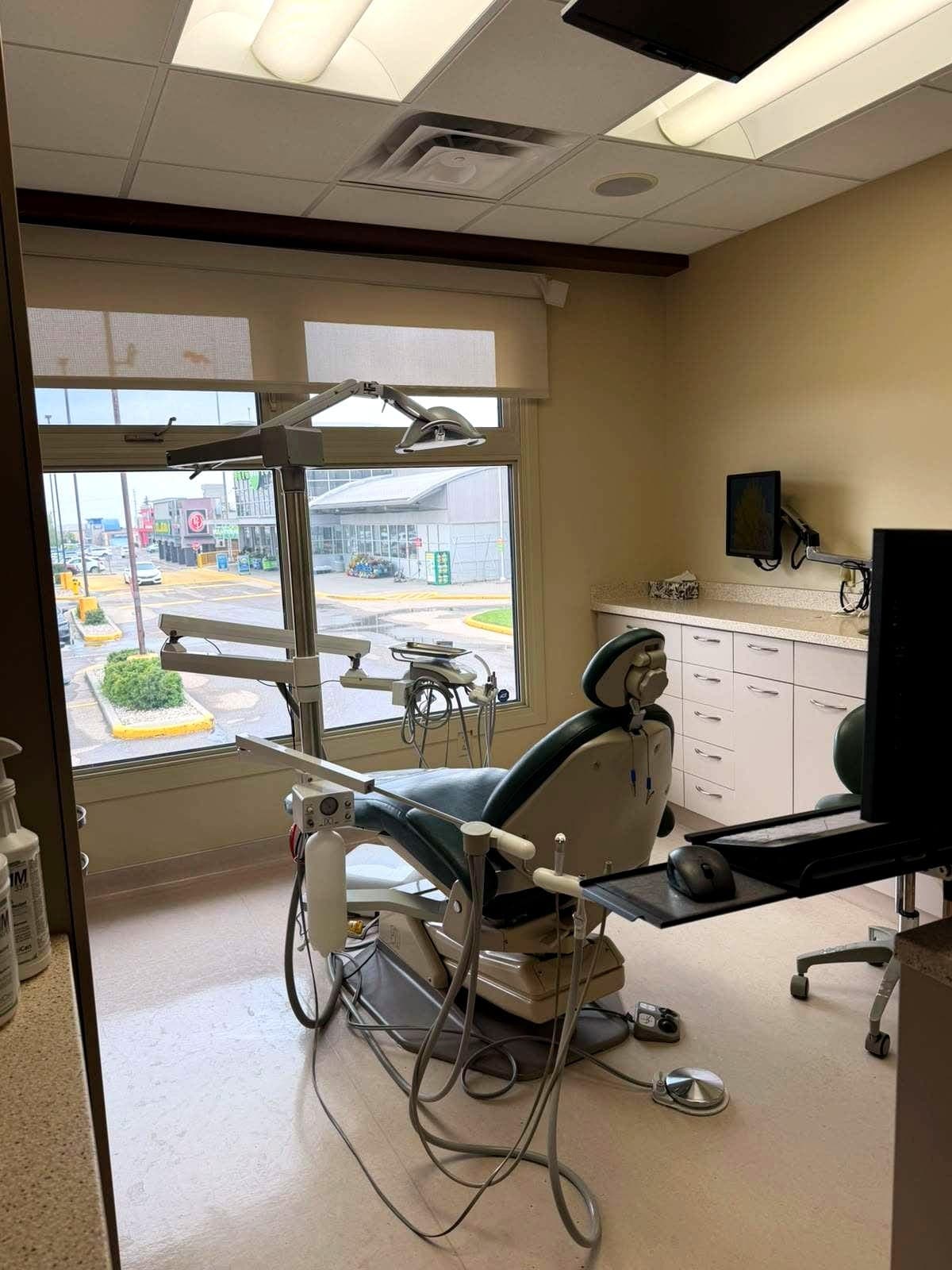 Bright dental treatment room with a large window and modern equipment