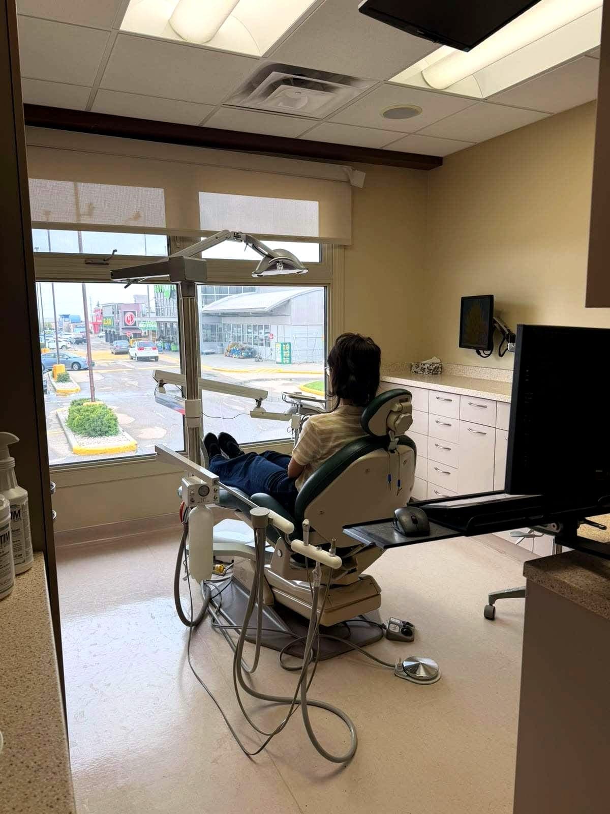 Treatment room with patient chair, overhead light and chairside monitor
