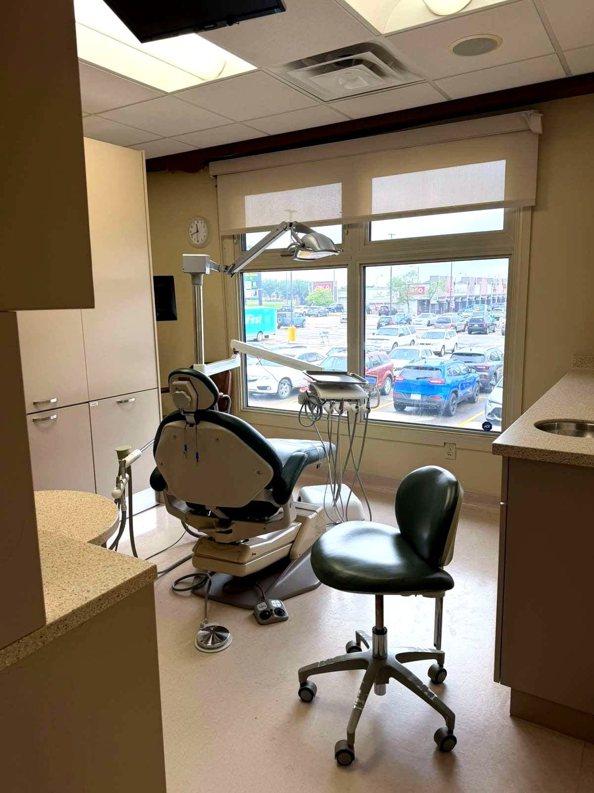 Dental operatory with green chairs and a bright street-facing window