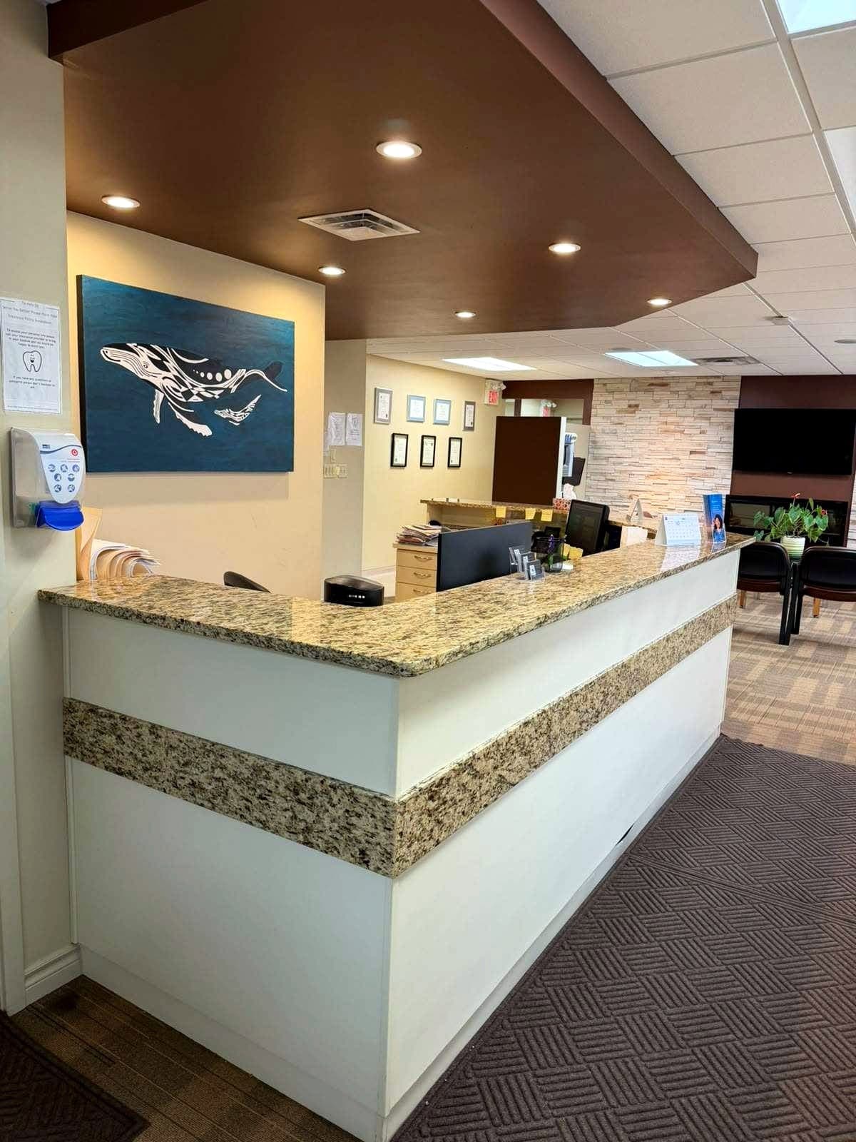 Front reception desk at Sherwood Park Dental Care Centre with hand-painted whale mural